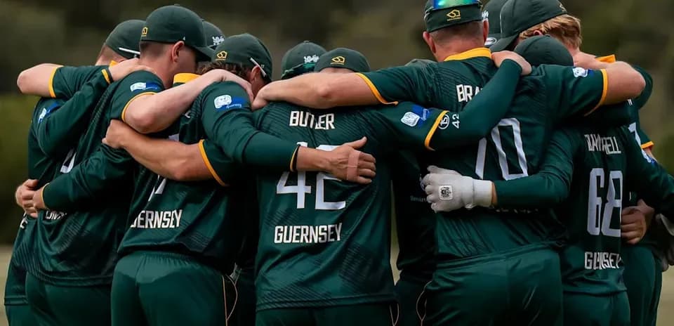 Jugadores de Guernsey abrazados en círculo