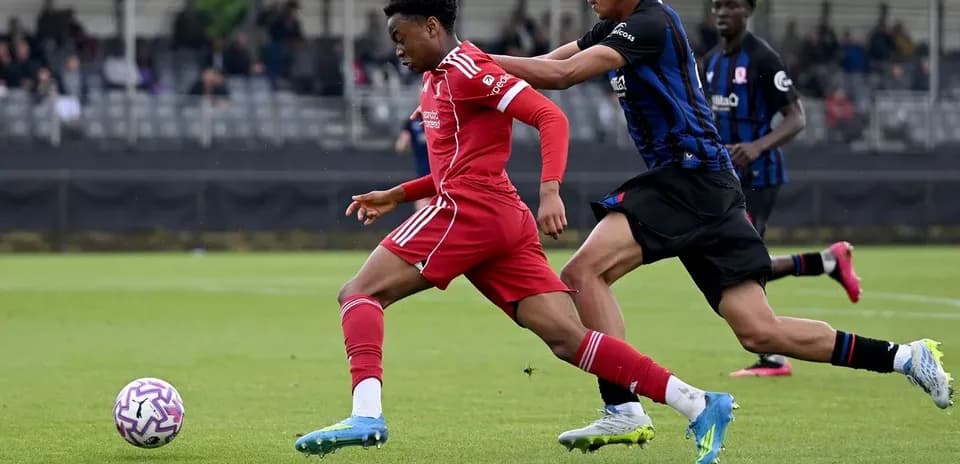 Jugador de Liverpool driblando mientras es perseguido