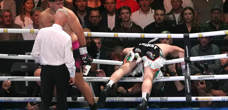 Boxeador caído en el ring durante la pelea