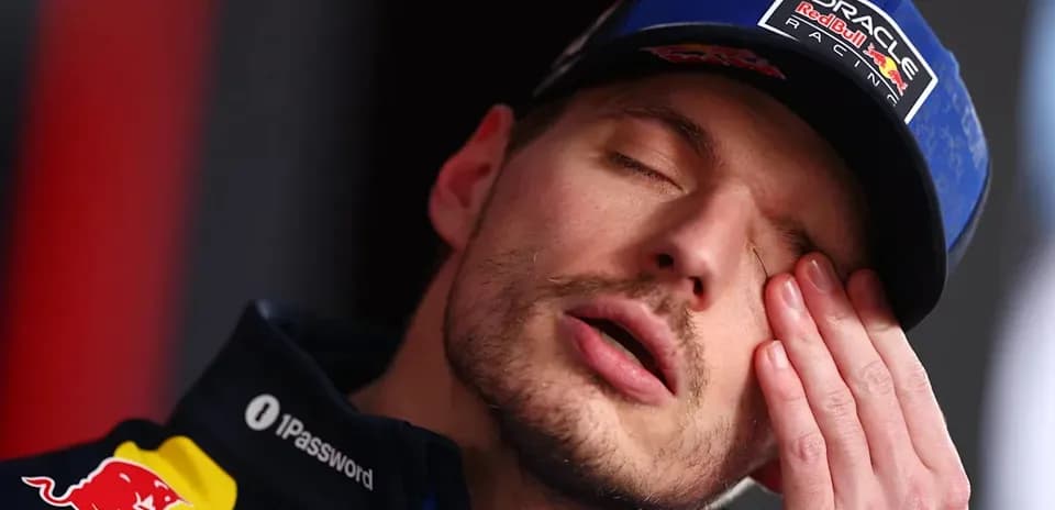Piloto con gorra de Red Bull tocándose la cara