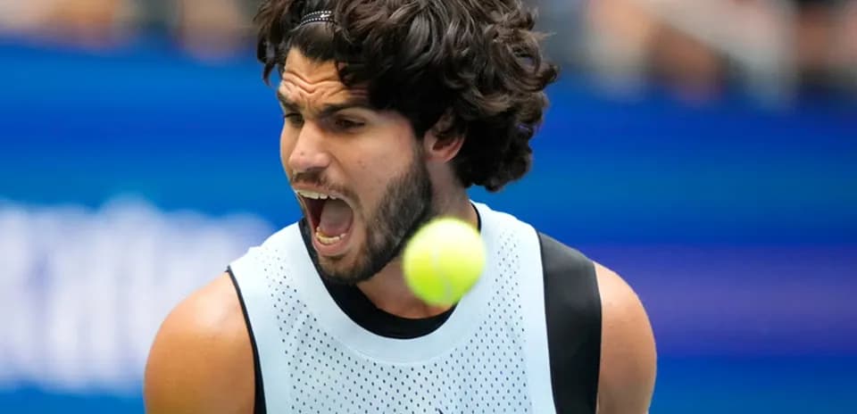 Jugador de tenis golpeando una pelota en la cancha