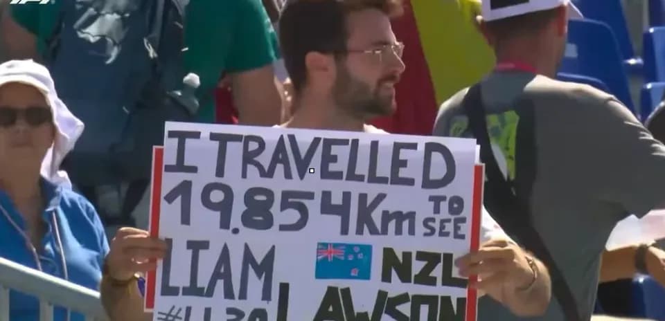 Espectador con cartel de apoyo a Liam Lawson