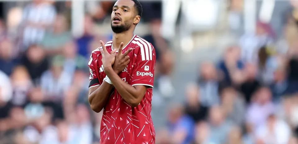 Jugador con camiseta roja mostrando las manos en el campo