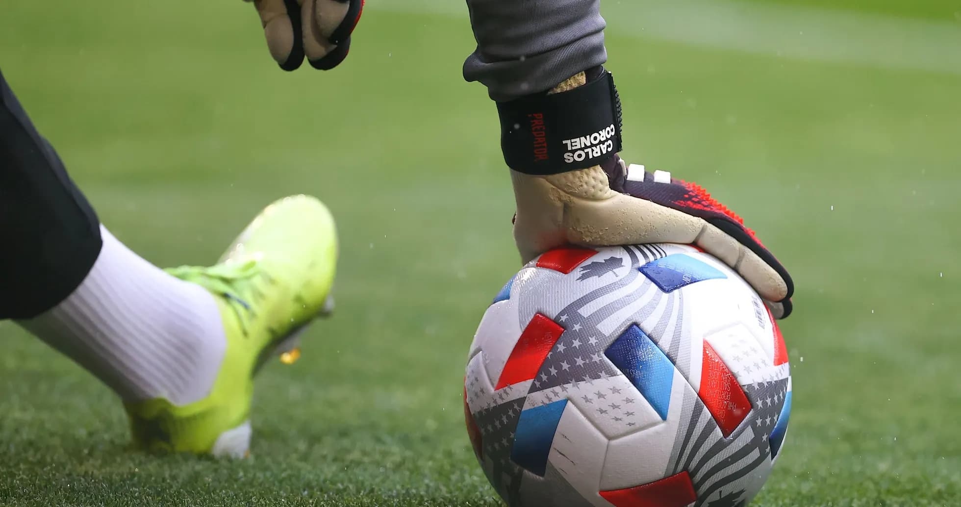 Portero sosteniendo balón de fútbol en el campo