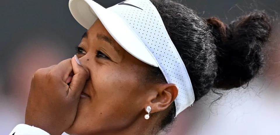 Naomi Osaka con visera y tocando su nariz