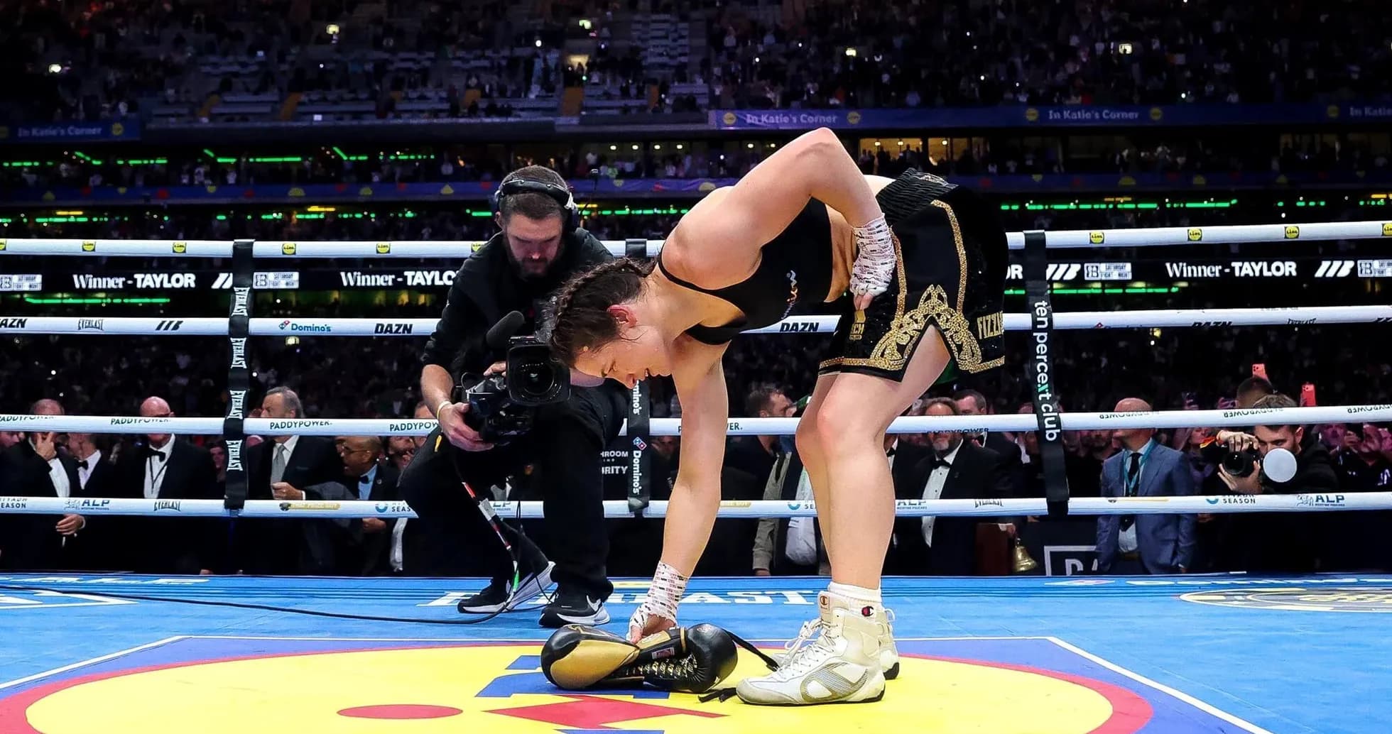 Boxeadora recogiendo guantes en el ring