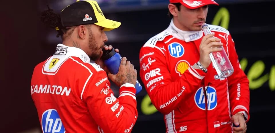 Dos pilotos de Fórmula 1 bebiendo agua en pits
