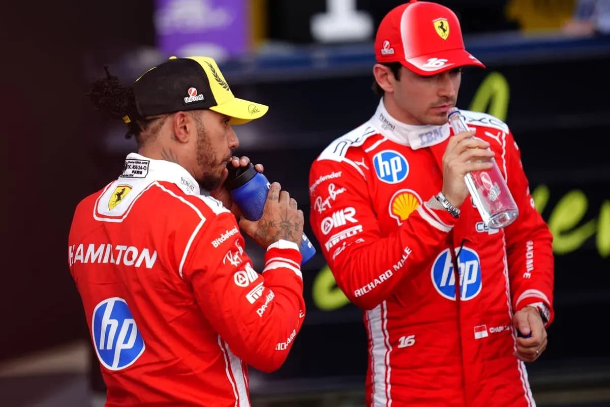 Dos pilotos de Fórmula 1 bebiendo agua en pits