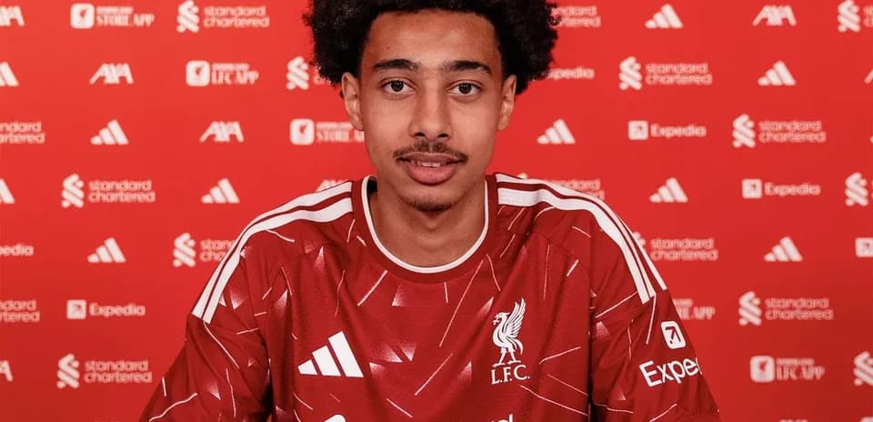 Jugador firmando contrato con Liverpool en conferencia