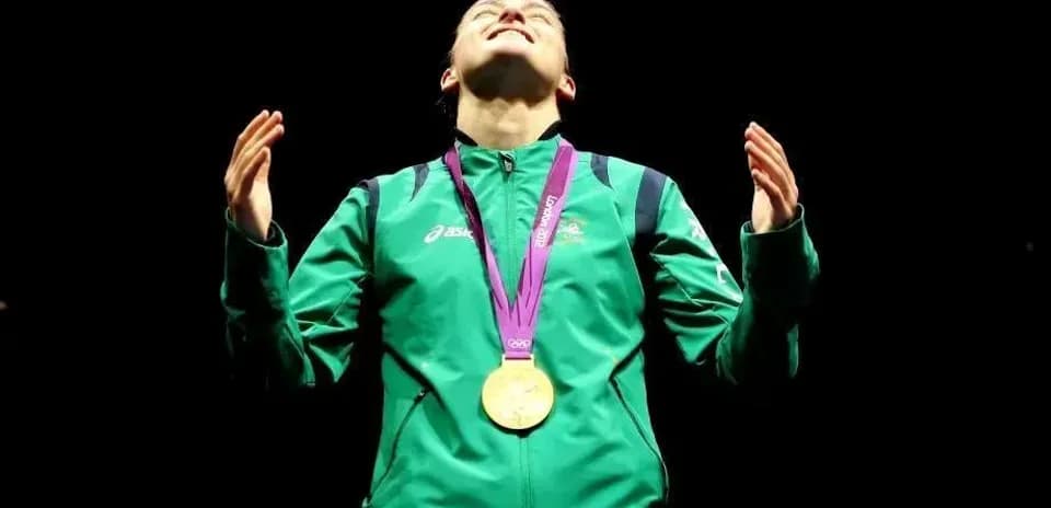 Atleta con medalla de oro levantando las manos