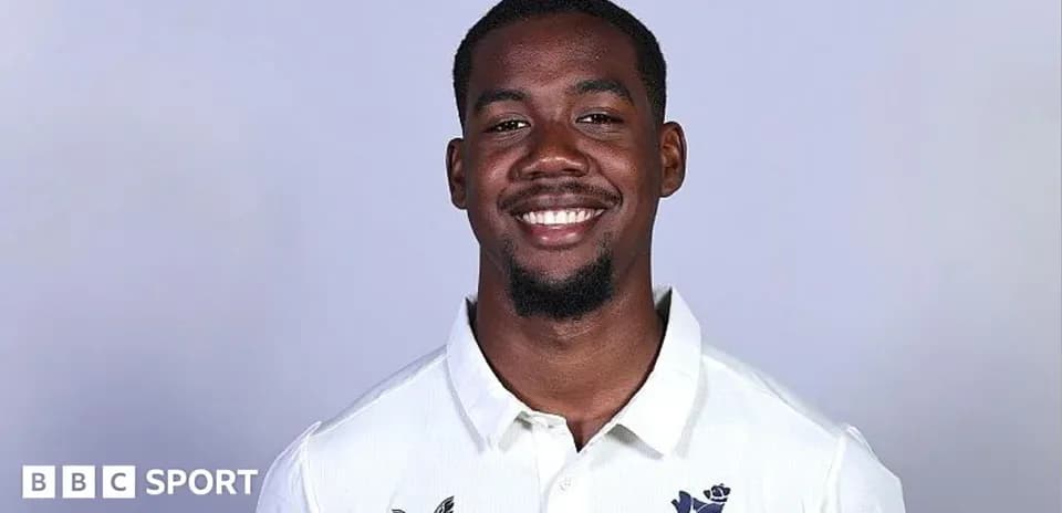 Jugador sonriendo en camiseta blanca con logo