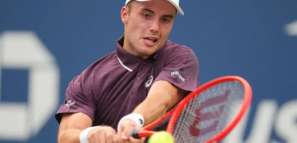 Jugador de tenis golpeando una pelota en la cancha