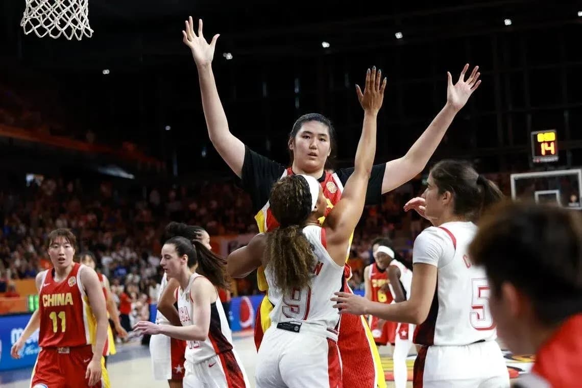 Jugadora bloqueando un tiro en partido de baloncesto