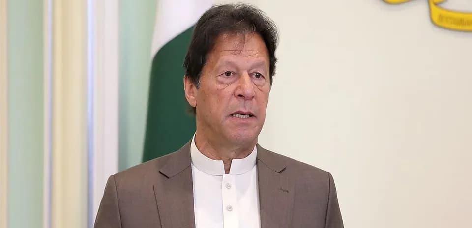Persona hablando en un podio con bandera de Pakistán