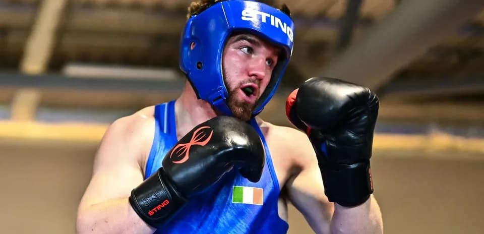 Boxeador entrenando con casco y guantes en gimnasio
