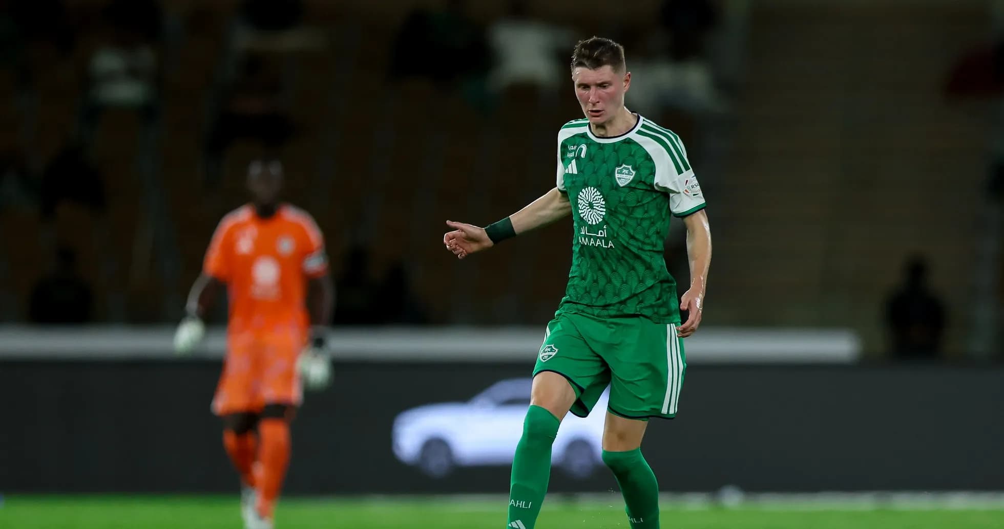 Jugador con camiseta verde en el campo de fútbol