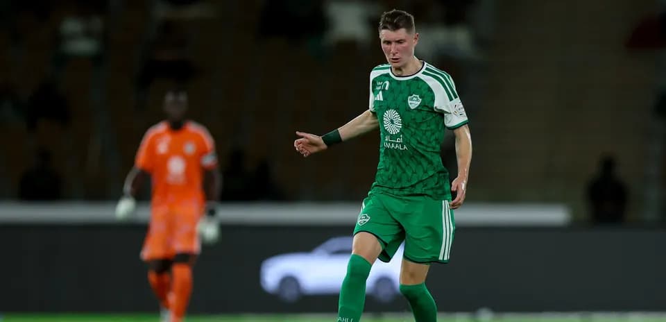 Jugador con camiseta verde en el campo de fútbol