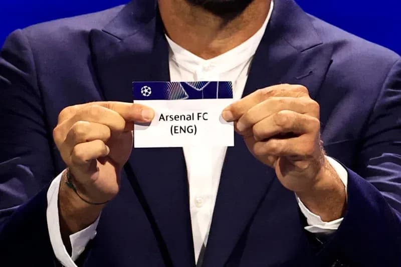 Persona sosteniendo tarjeta de Arsenal FC (ENG)
