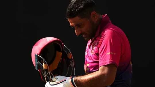 Jugador de cricket ajustando su casco antes de jugar