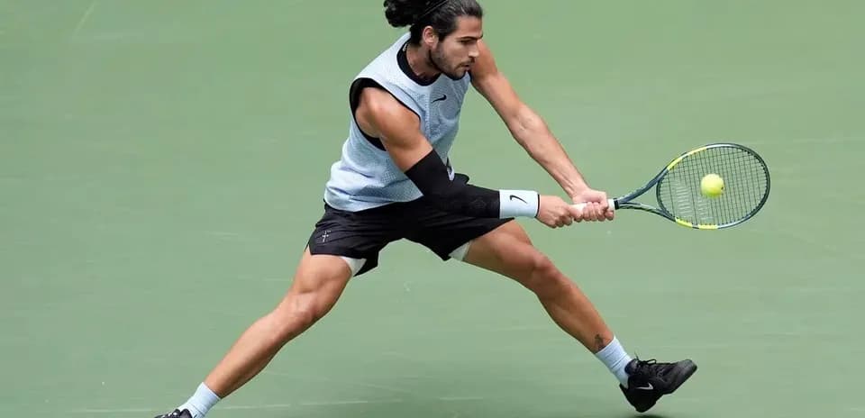 Jugador de tenis golpeando la pelota en cancha