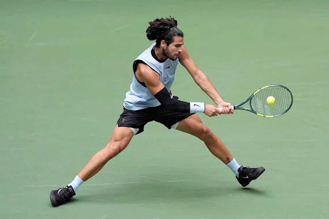 Jugador de tenis golpeando la pelota en cancha