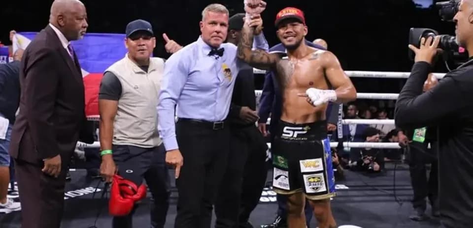 Boxeador levantando el puño tras victoria en el ring