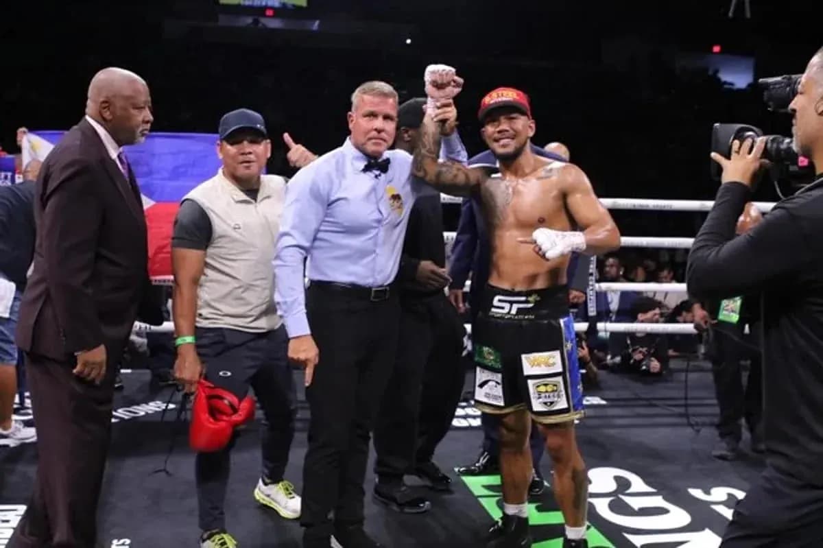 Boxeador levantando el puño tras victoria en el ring