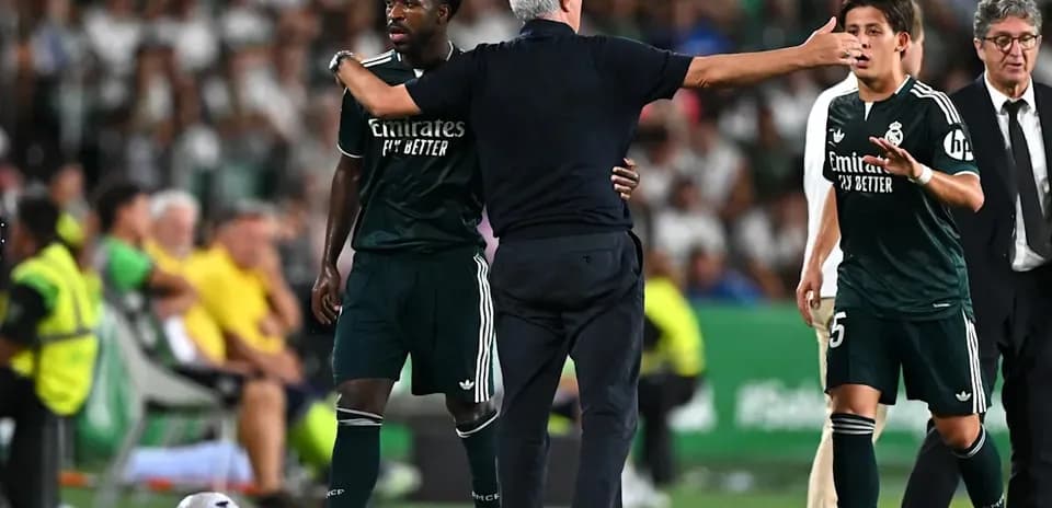 Entrenador instruyendo a jugadores en el banquillo
