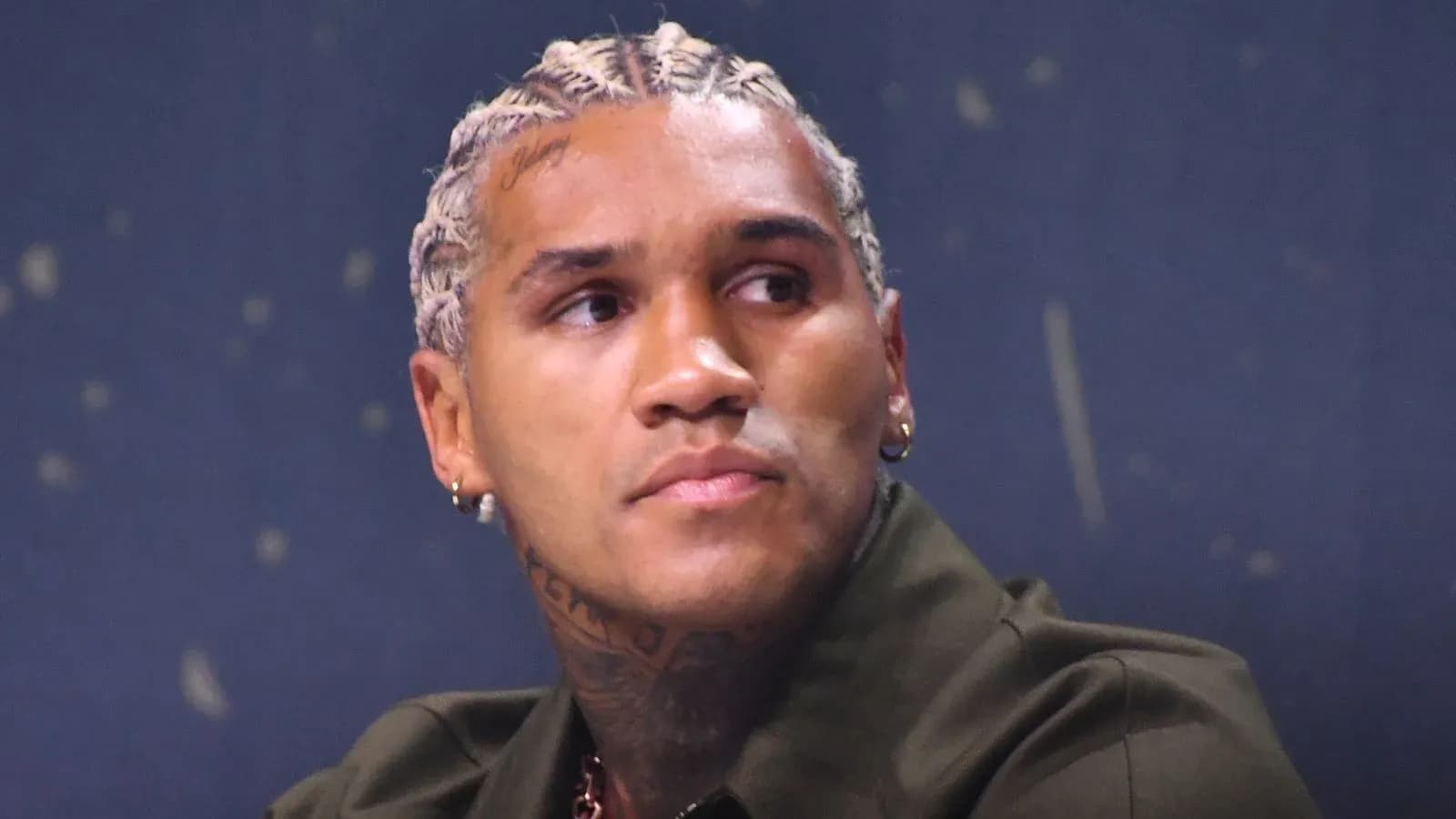 Jugador con trenzas sentado en conferencia de prensa