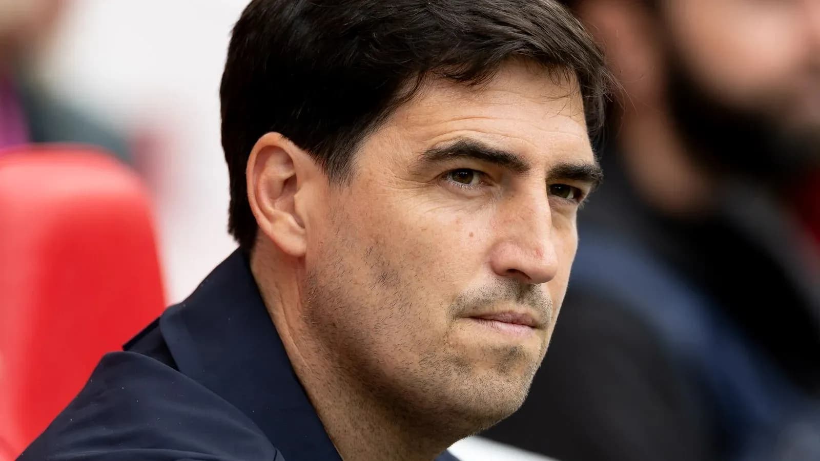 Entrenador sentado en el banquillo durante el partido