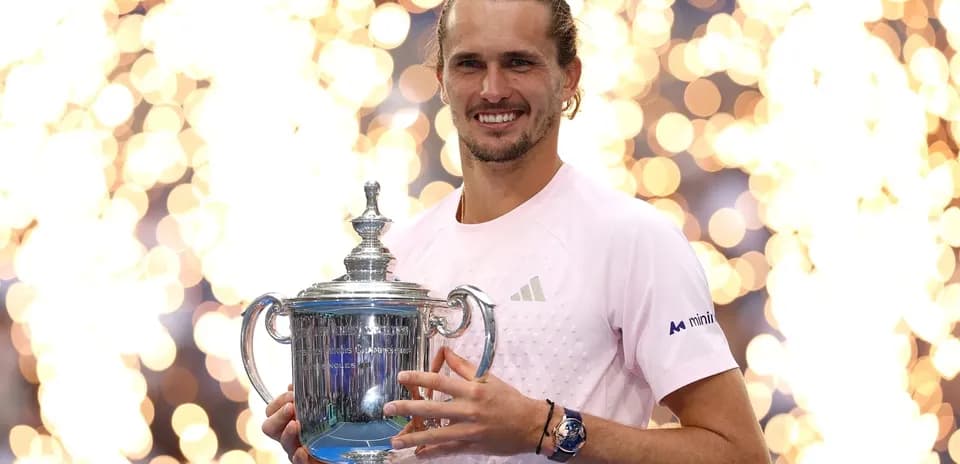 Jugador sosteniendo trofeo de tenis con fondo brillante