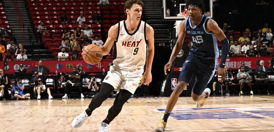 Jugador de Miami Heat driblando balón ante defensor