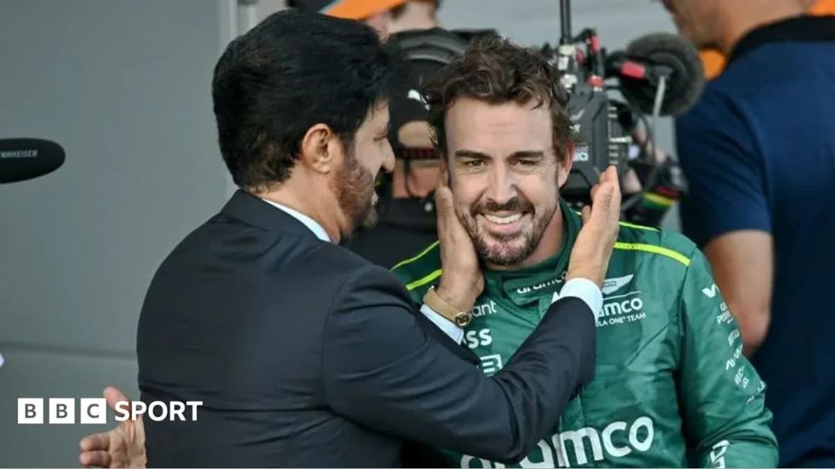 Fernando Alonso sonriendo con un compañero en el paddock