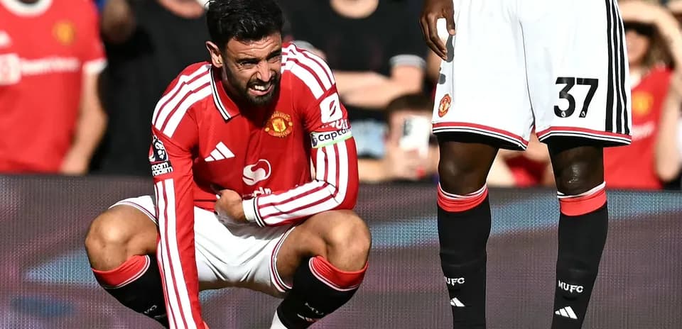 Bruno Fernandes crouching on the pitch in pain