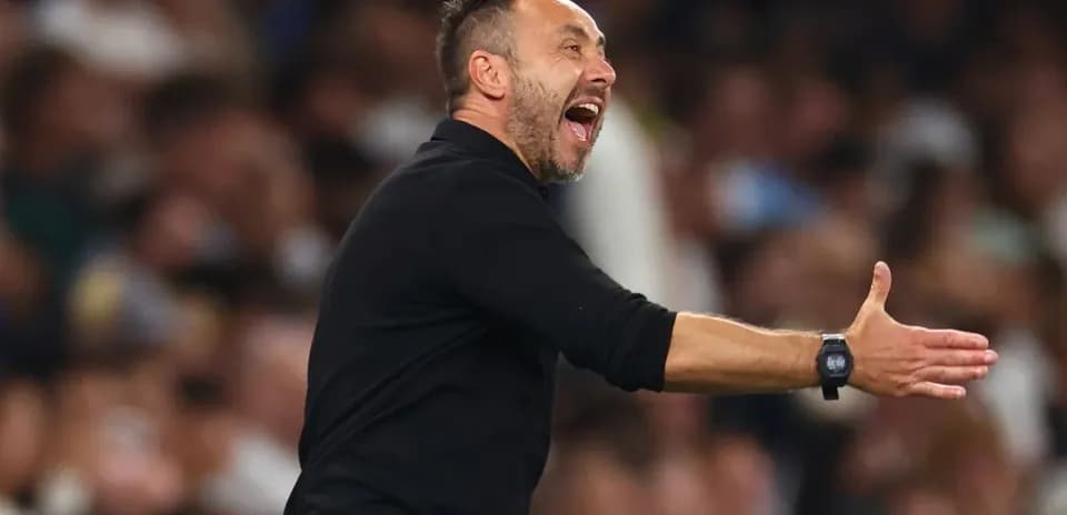 Entrenador gesticulando durante un partido de fútbol