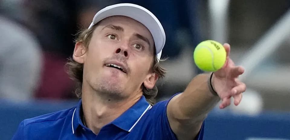 Jugador de tenis lanzando una pelota al servicio