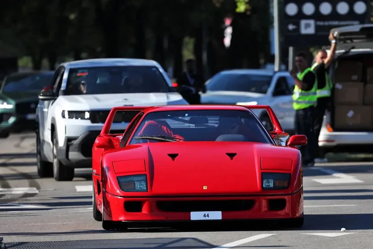 Ferrari rojo circulando entre otros vehículos en la calle