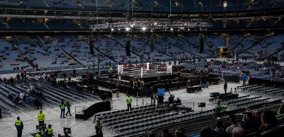 Ring de boxeo en estadio con público presente