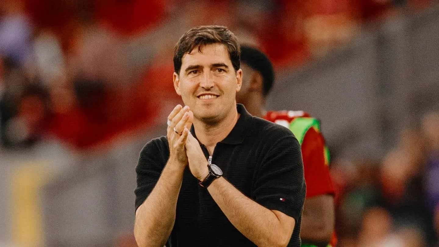 Entrenador aplaudiendo en el banquillo del estadio