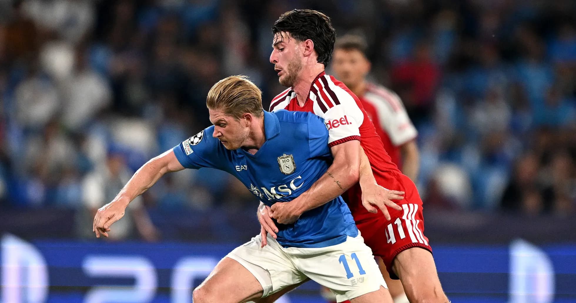 Jugador en camiseta azul siendo marcado por oponente