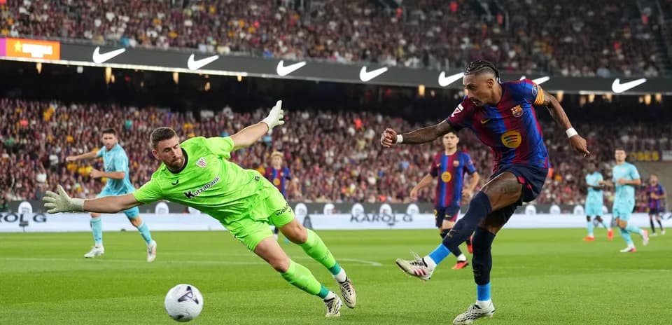 Jugador de Barcelona dispara mientras el portero intenta detenerlo