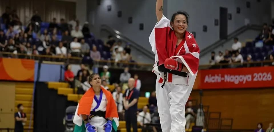 Competidora levantando el puño tras ganar combate de karate