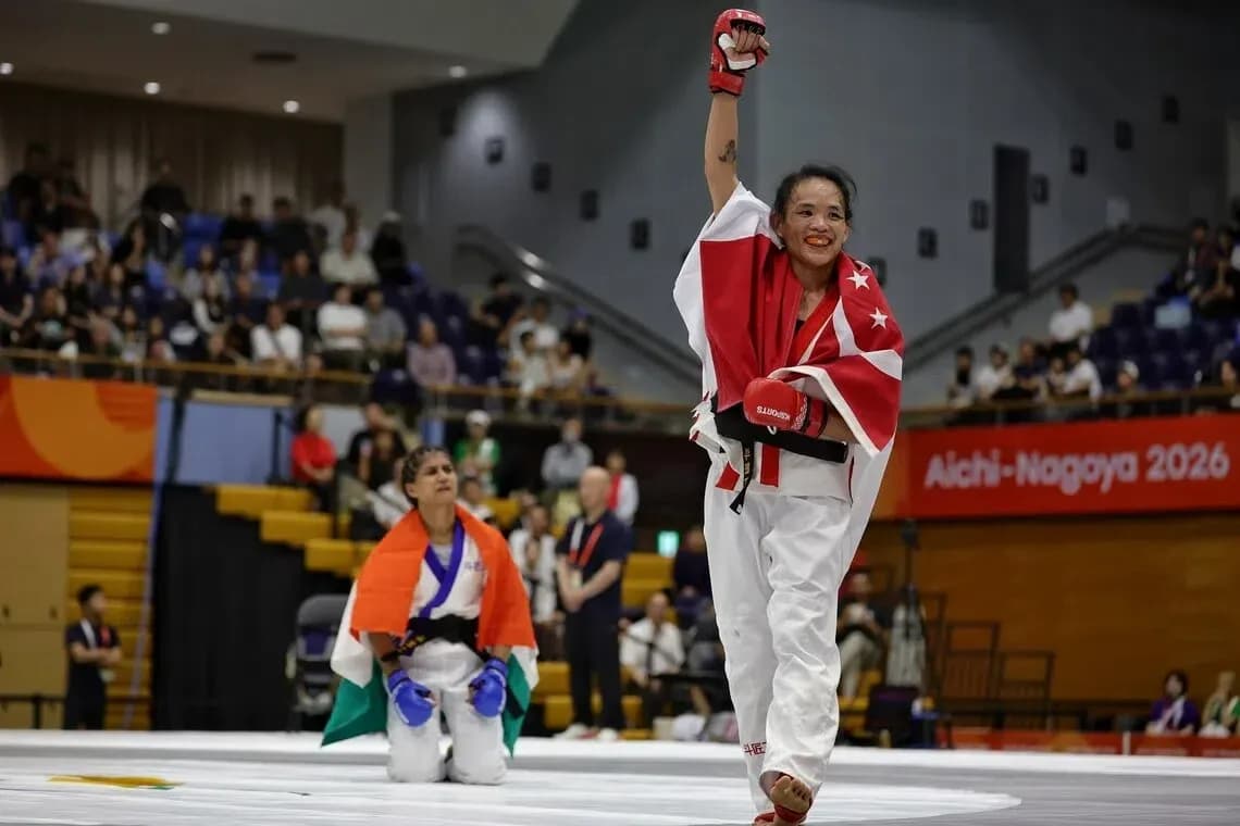 Competidora levantando el puño tras ganar combate de karate