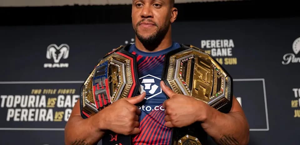 Luchador sosteniendo dos cinturones de campeón