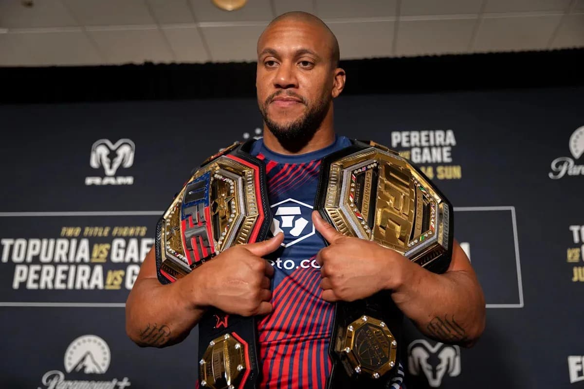 Luchador sosteniendo dos cinturones de campeón