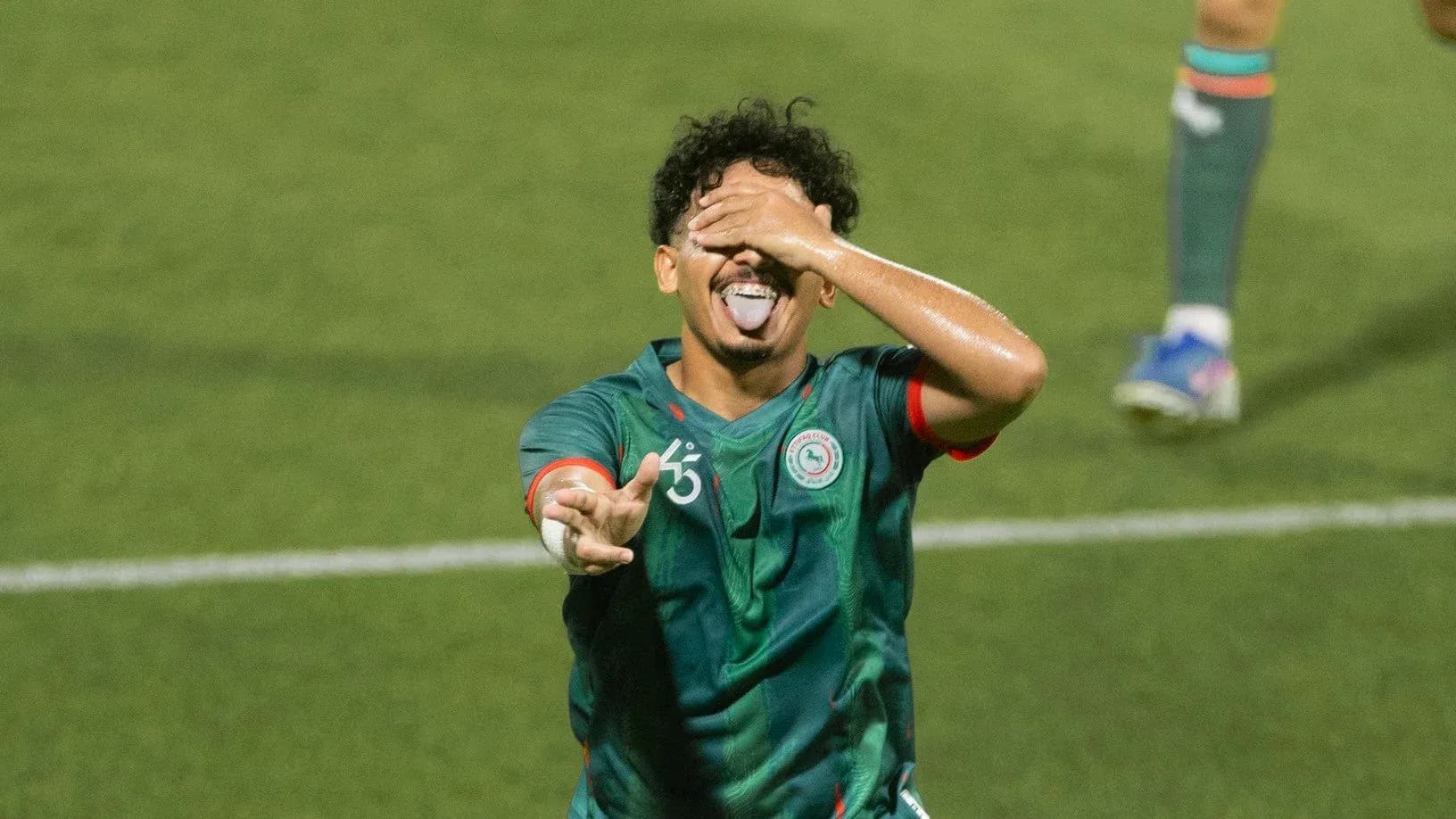 Jugador celebrando con la lengua afuera en el campo