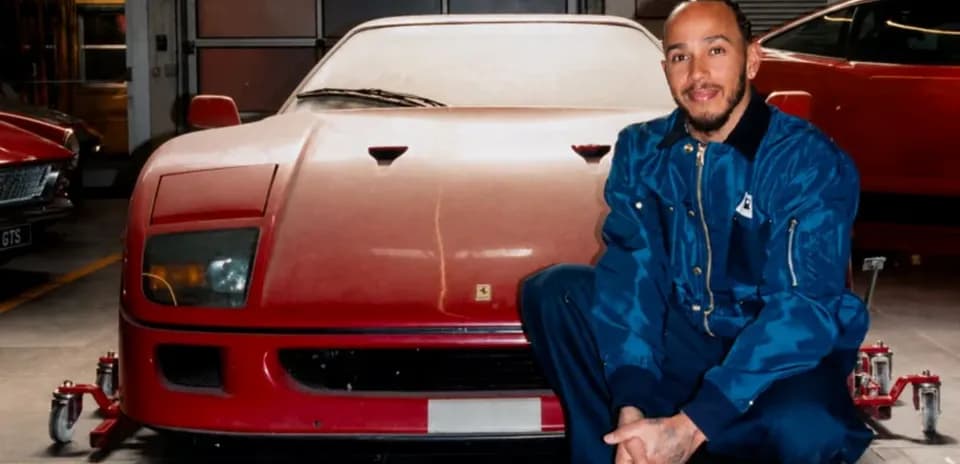 Hombre posando junto a un coche Ferrari rojo