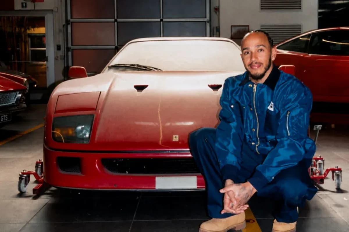 Hombre posando junto a un coche Ferrari rojo
