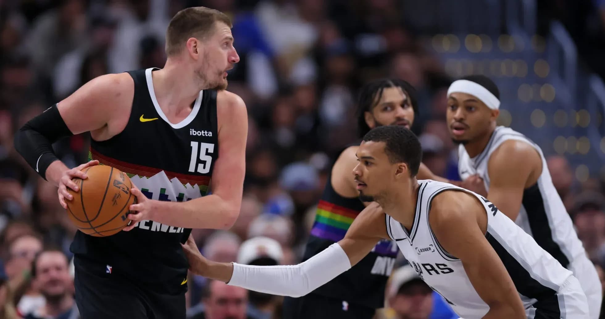 Jugador de Denver driblando mientras es defendido