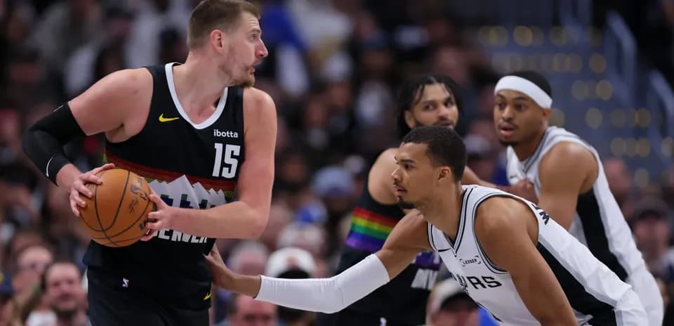 Jugador de Denver driblando mientras es defendido